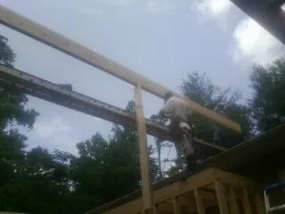 Carpenter setting a ridge beam over a new addition frame — Ice Dam Removal by Roofing Brothers in Snow Camp