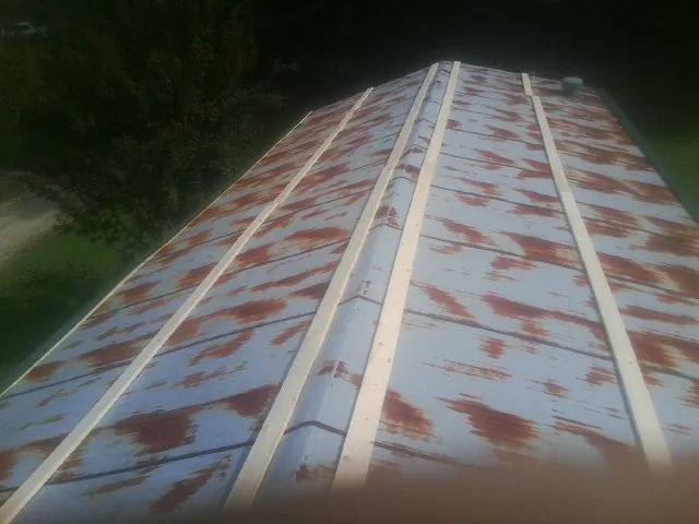 Rusted metal roof panels with new wood purlins before replacement — Storm Damage Roof Repair in Snow Camp by Roofing Brothers