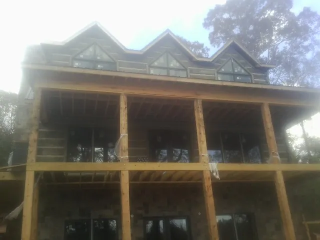 Dormers and porch framing on a large log home under construction — Roof Coating work by our crew in Snow Camp