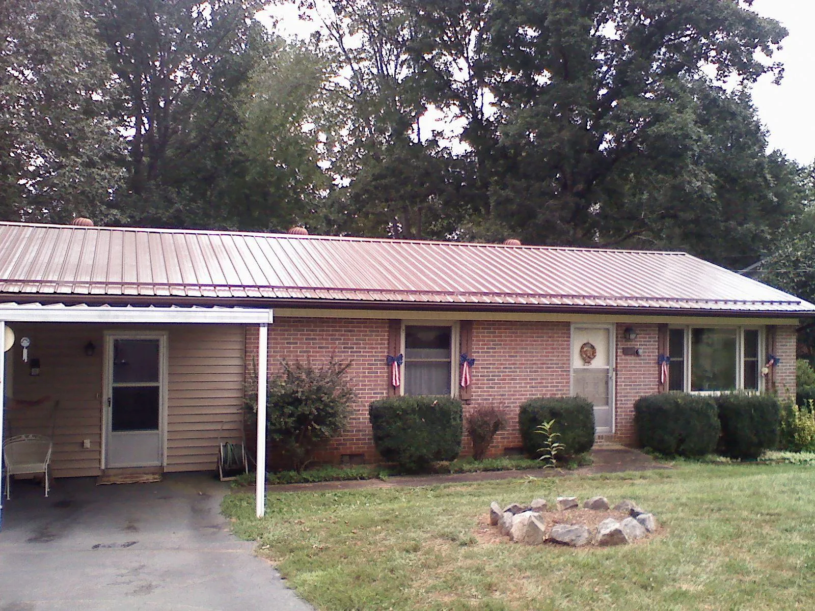 Bronze metal roof and carport on a brick ranch home — Roof Repair work by our crew in Snow Camp
