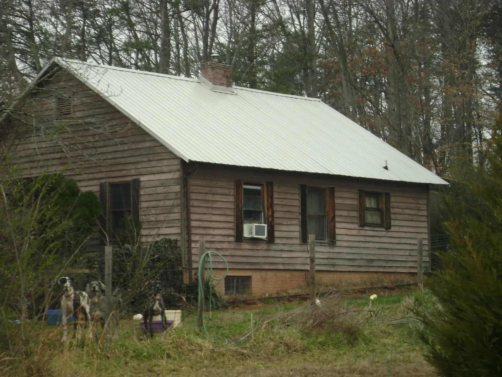 White metal roof on an old wood sided farmhouse, from a Metal Roof Installation job in Snow Camp